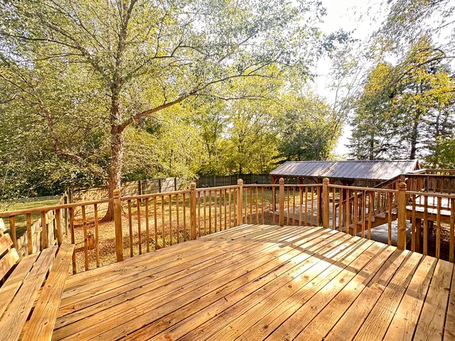 a view of a balcony with wooden floor and fence