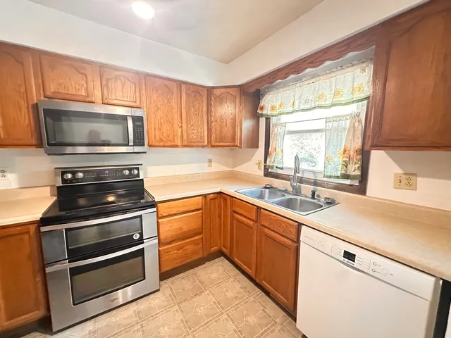 a kitchen with granite countertop cabinets stainless steel appliances and a window
