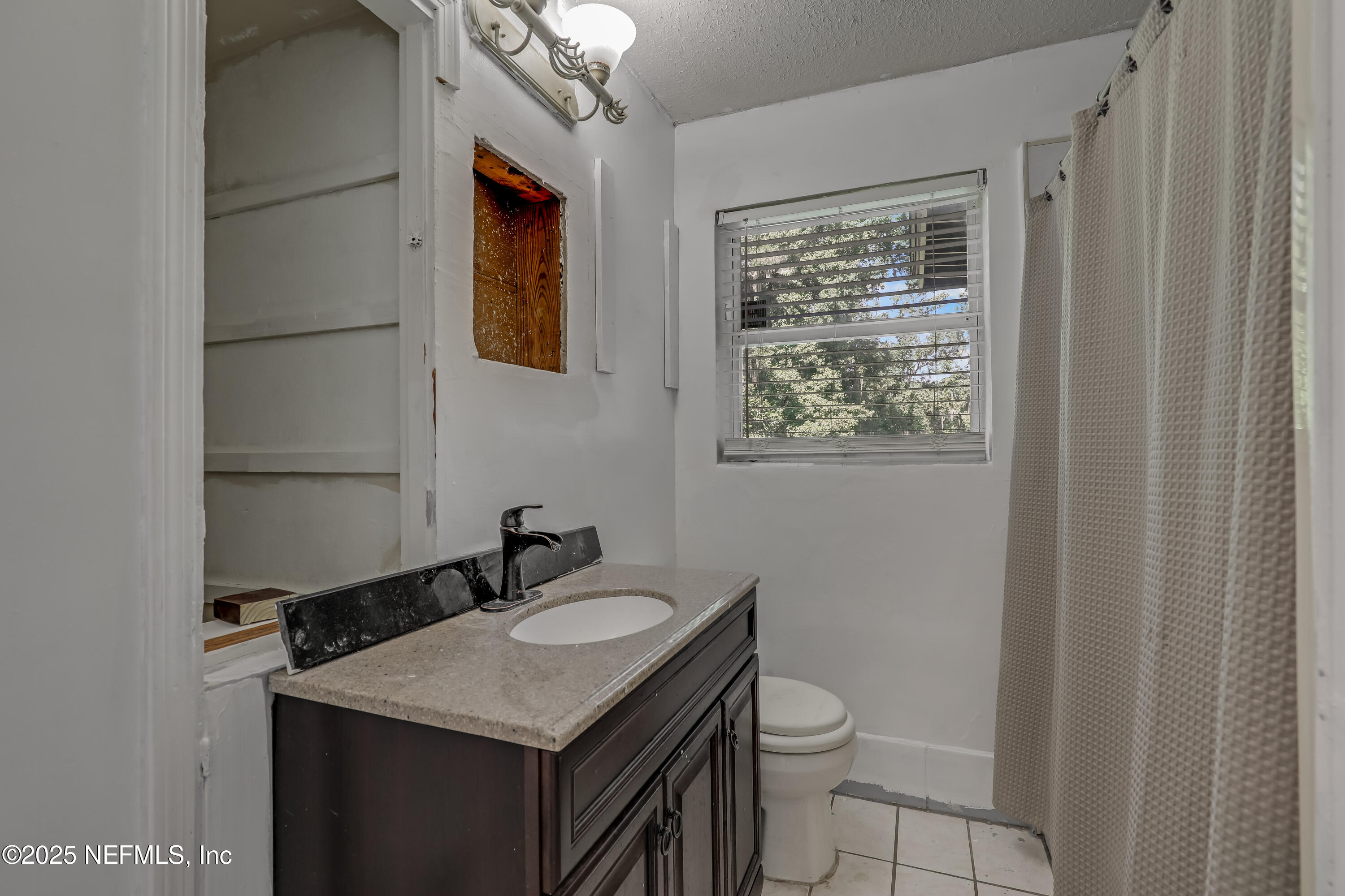 10524 Rutgers Road Jacksonville, FL 32218 - Photo 28 of 46 a bathroom with a granite countertop sink toilet and mirror