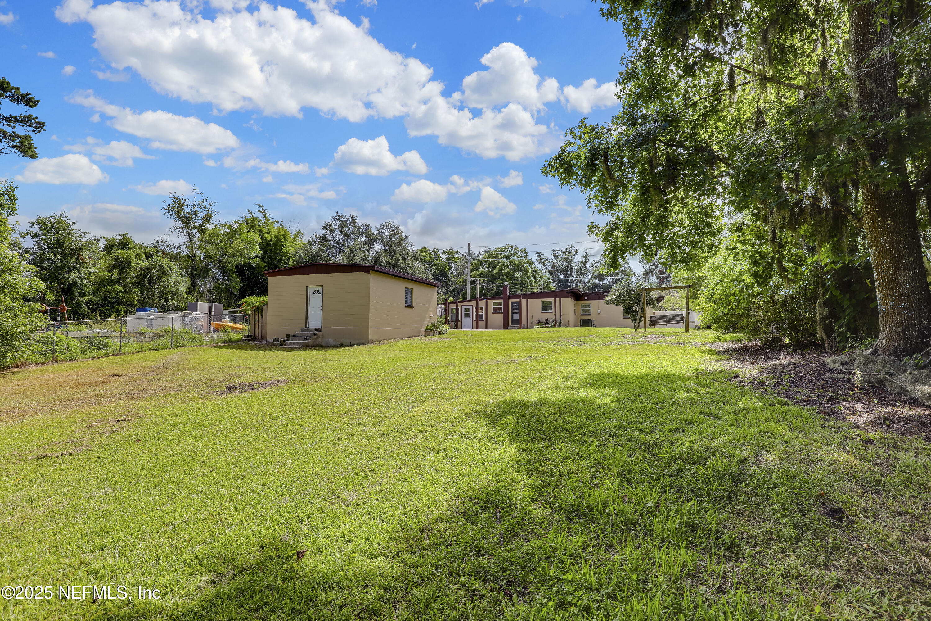 10524 Rutgers Road Jacksonville, FL 32218 - Photo 39 of 46 a view of a big yard with swimming pool and trees in the background