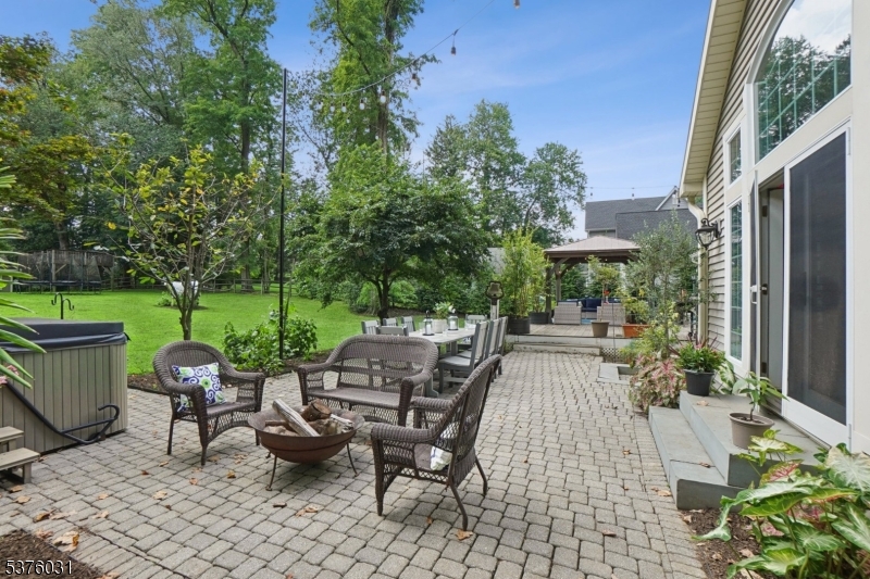 21 Spring Street Chatham, NJ 07928 - Photo 37 of 48 a view of a patio with table and chairs potted plants and a palm tree