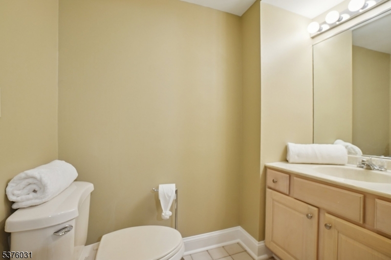 21 Spring Street Chatham, NJ 07928 - Photo 42 of 48 a bathroom with a toilet sink vanity and mirror