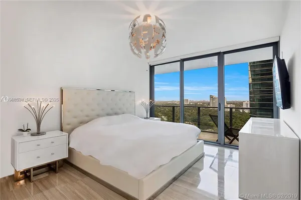 a living room with flat screen tv and a chandelier