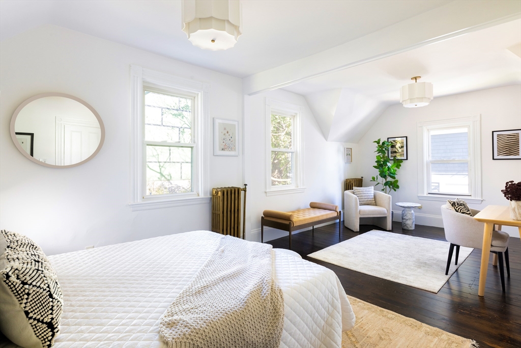9 Carver Street Somerville, MA 02143 - Photo 8 of 11 a bedroom with two beds and a large mirror next to a window