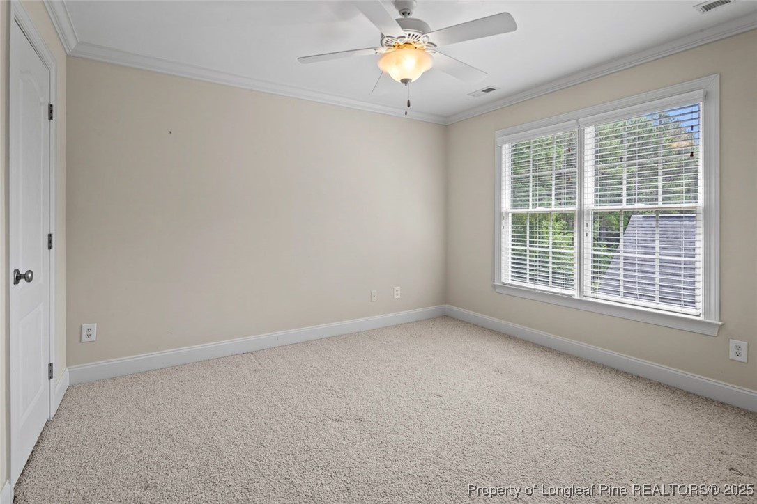 259 Rolling Pines Drive Spring Lake, NC 28390 - Photo 44 of 50 en empty room with windows and chandelier fan