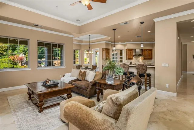 a kitchen with stainless steel appliances kitchen island granite countertop a stove top oven a sink a dining table and chairs with wooden floor