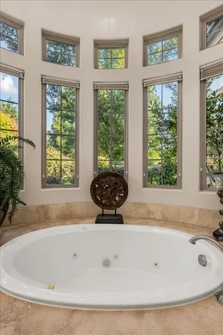 a white bath tub sitting in a bathroom next to a window