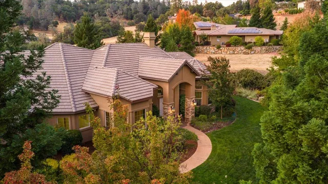 a front view of a house with a yard and trees