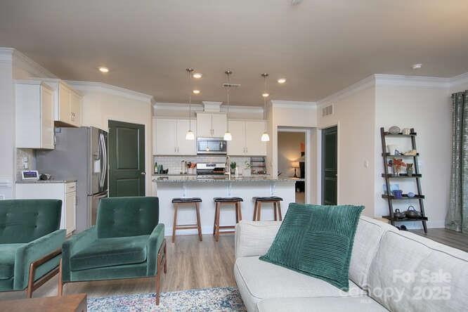 4245 Millstream Road Denver, NC 28037 - Photo 19 of 47 a living room with stainless steel appliances kitchen island granite countertop furniture a rug a fireplace and a kitchen view