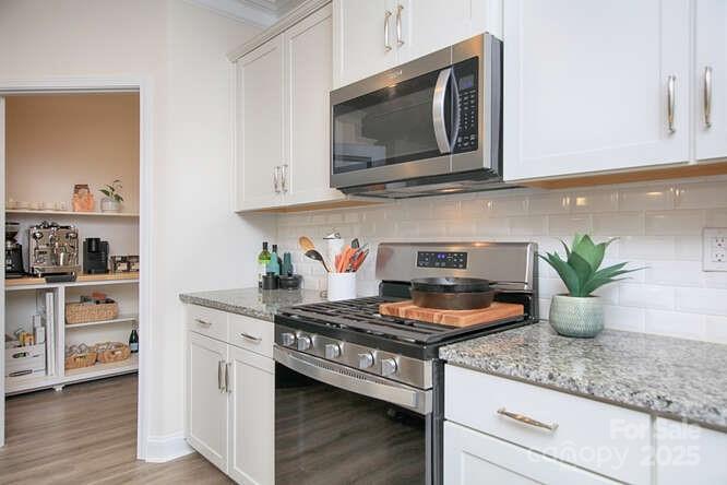 4245 Millstream Road Denver, NC 28037 - Photo 5 of 47 a kitchen with granite countertop stainless steel appliances stove microwave and cabinets