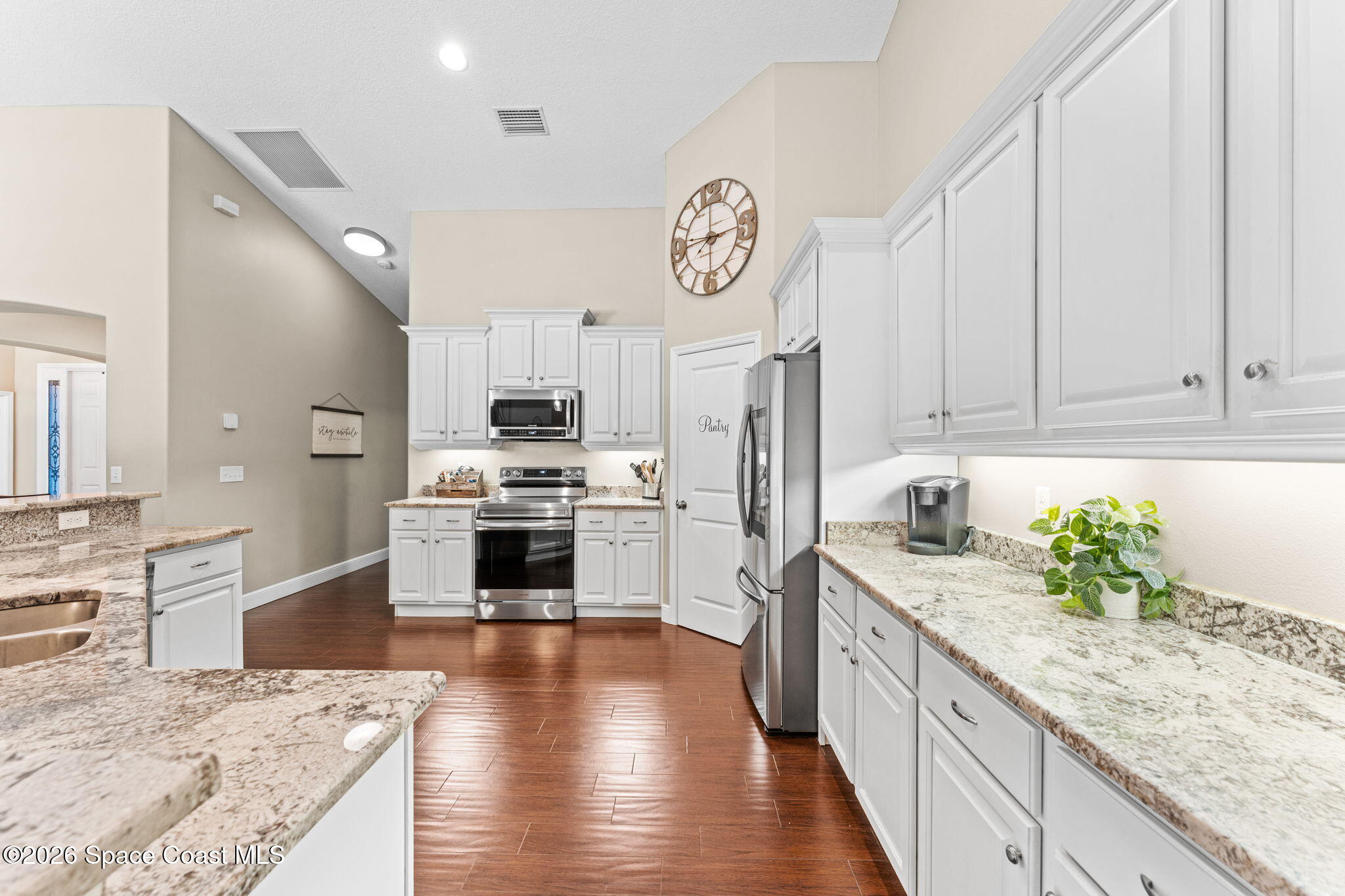 1695 Arch Road Mims, FL 32754 - Photo 19 of 57 a large kitchen with granite countertop a stove top oven a sink a counter space and cabinets