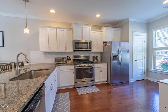 a kitchen with granite countertop a refrigerator and a sink