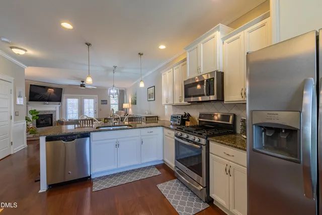 a kitchen with stainless steel appliances granite countertop a stove a sink and a refrigerator