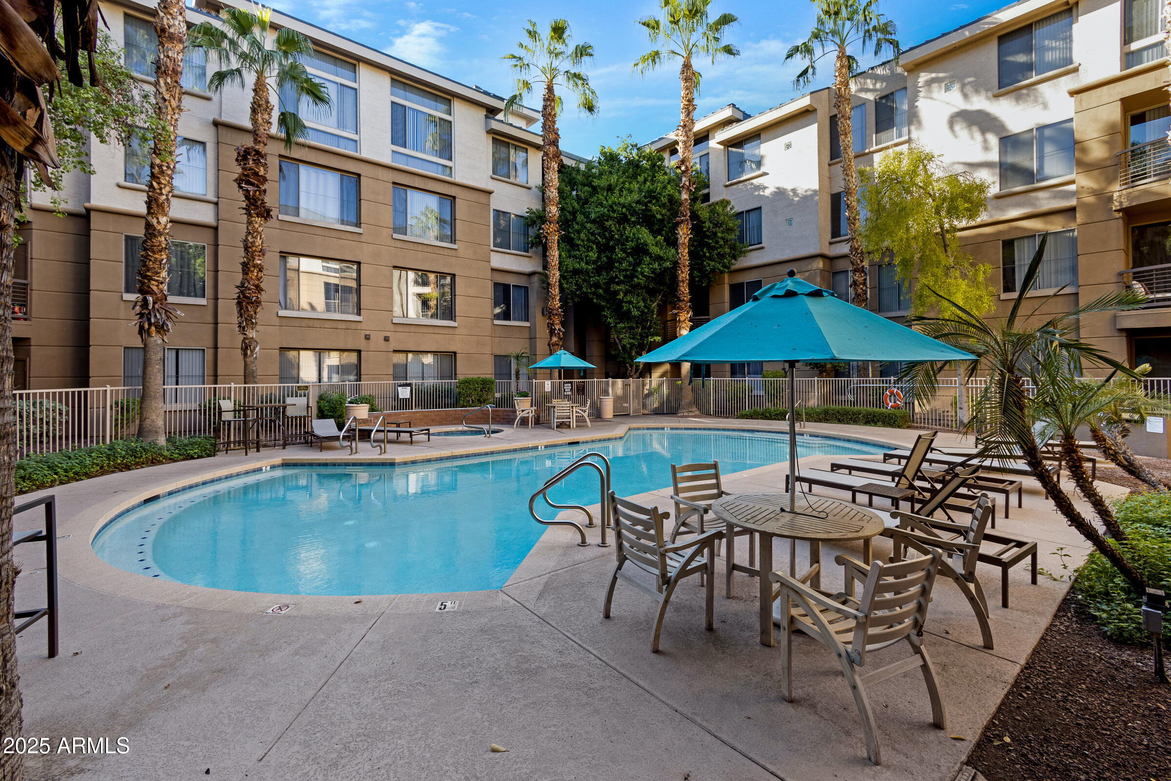 1701 East Colter Street, Unit 191 Phoenix, AZ 85016 - Photo 12 of 33 a view of a swimming pool with a table and chairs under an umbrella