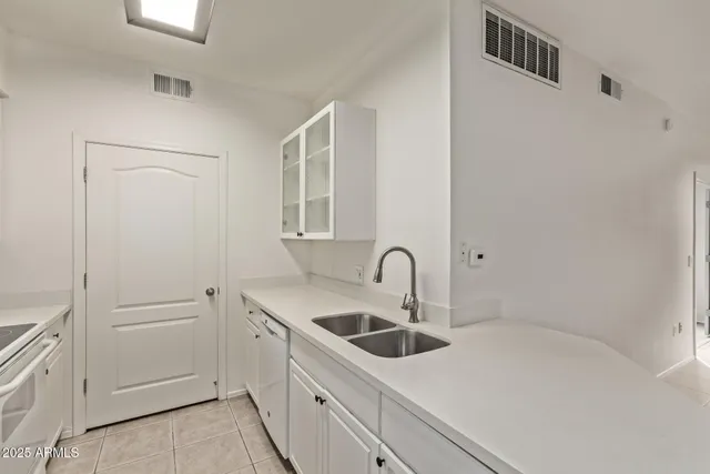 a kitchen with white cabinets and white appliances