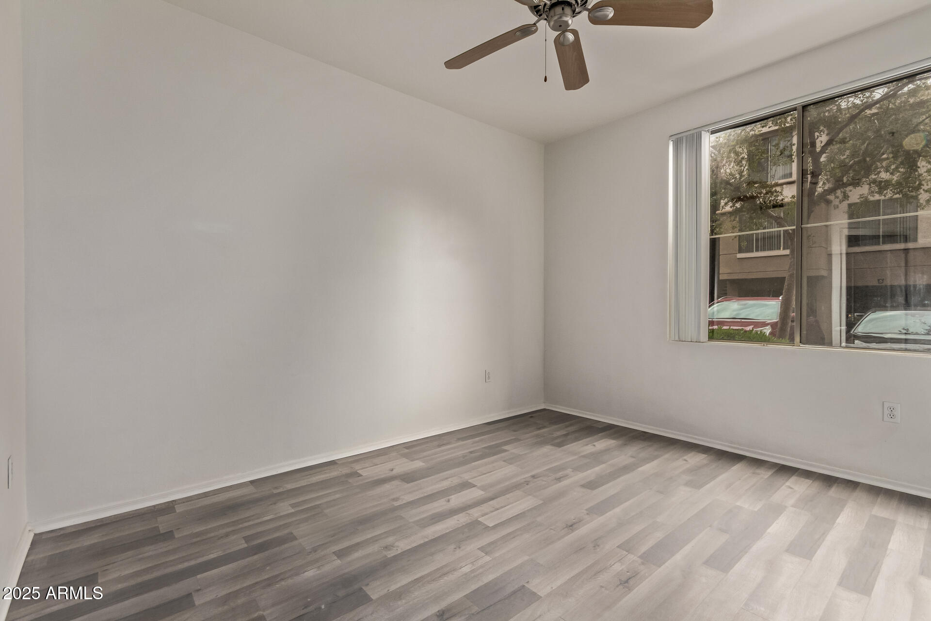 1701 East Colter Street, Unit 191 Phoenix, AZ 85016 - Photo 23 of 33 a view of an empty room with a window and wooden floor