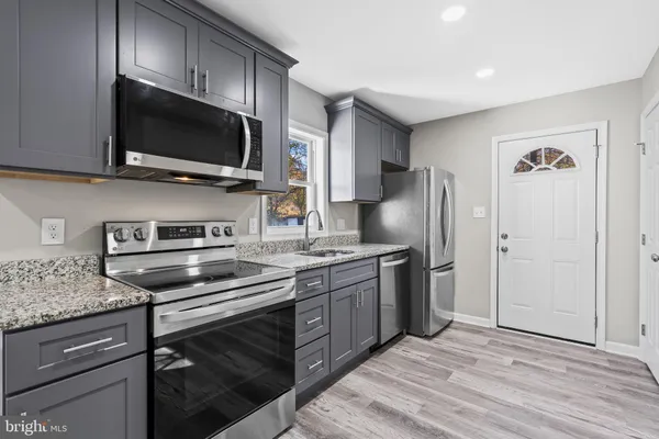 a kitchen with stainless steel appliances granite countertop a stove microwave and refrigerator