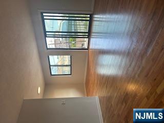148 Undercliff Avenue, Unit 2 Edgewater, NJ 07020 - Photo 9 of 13 a view of an empty room with wooden floor and a window