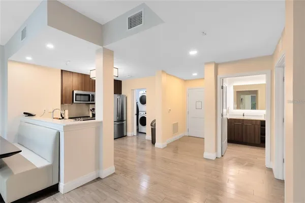 a view of a kitchen with refrigerator and wooden floor
