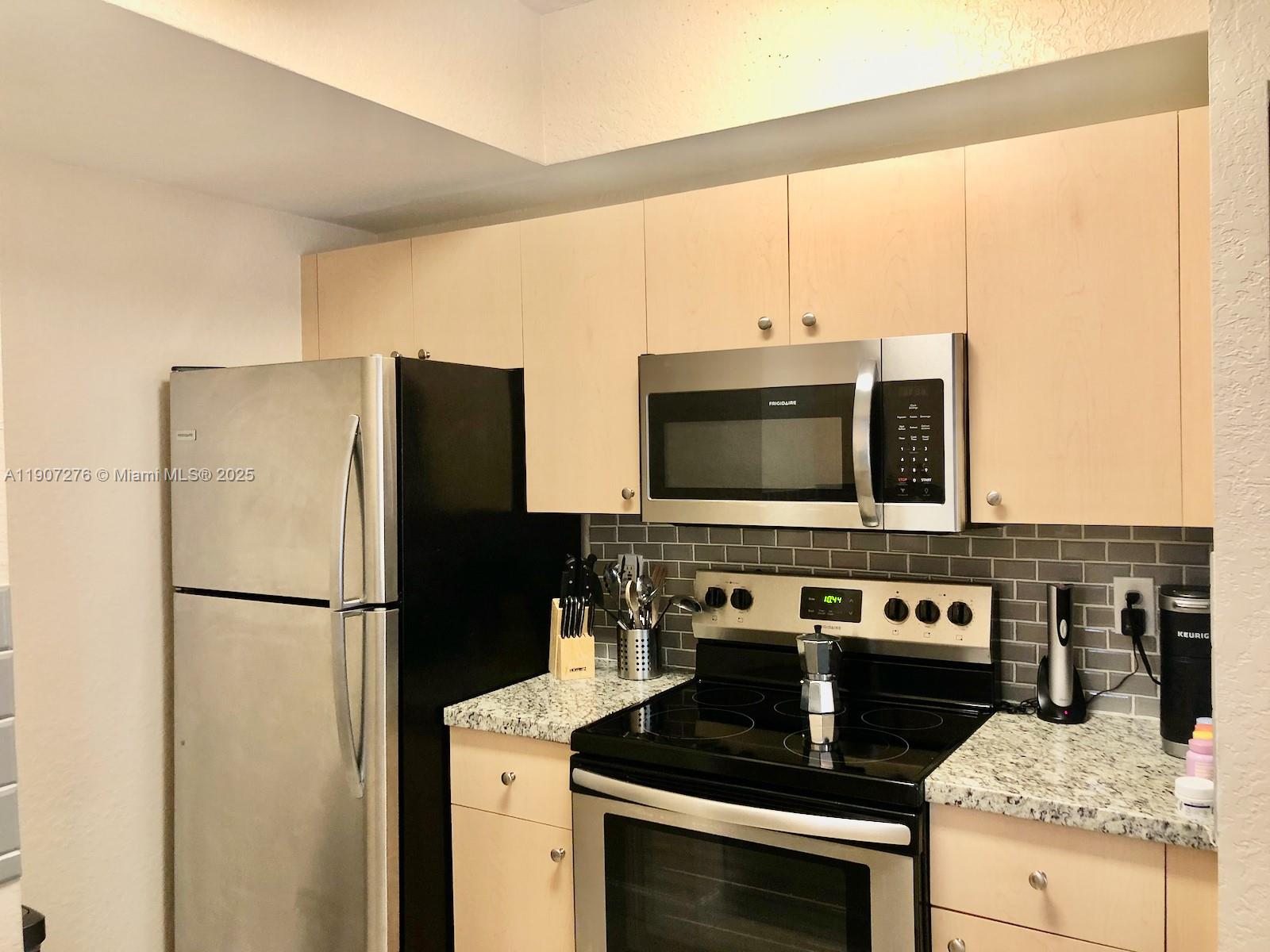 2532 Centergate Drive, Unit 102 Miramar, FL 33025 - Photo 12 of 58 a kitchen with a stove and a refrigerator