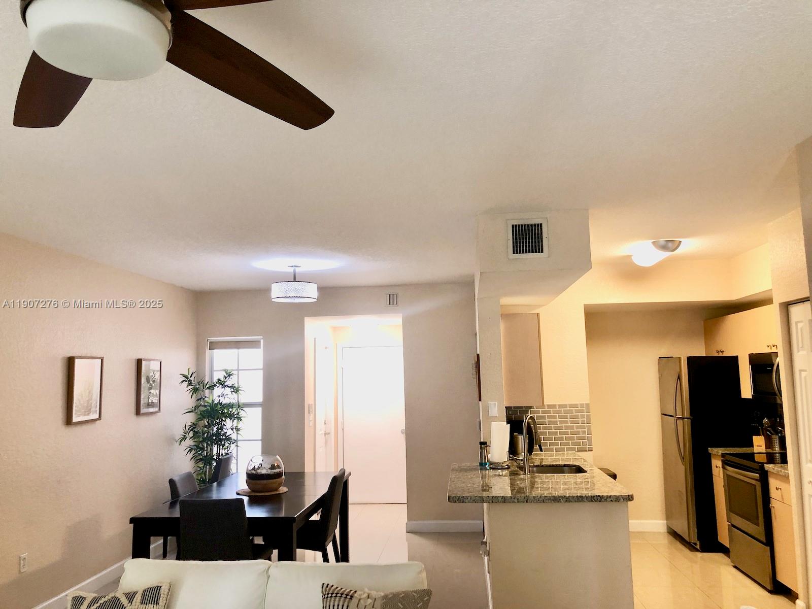 2532 Centergate Drive, Unit 102 Miramar, FL 33025 - Photo 18 of 58 a living room with furniture and a flat screen tv