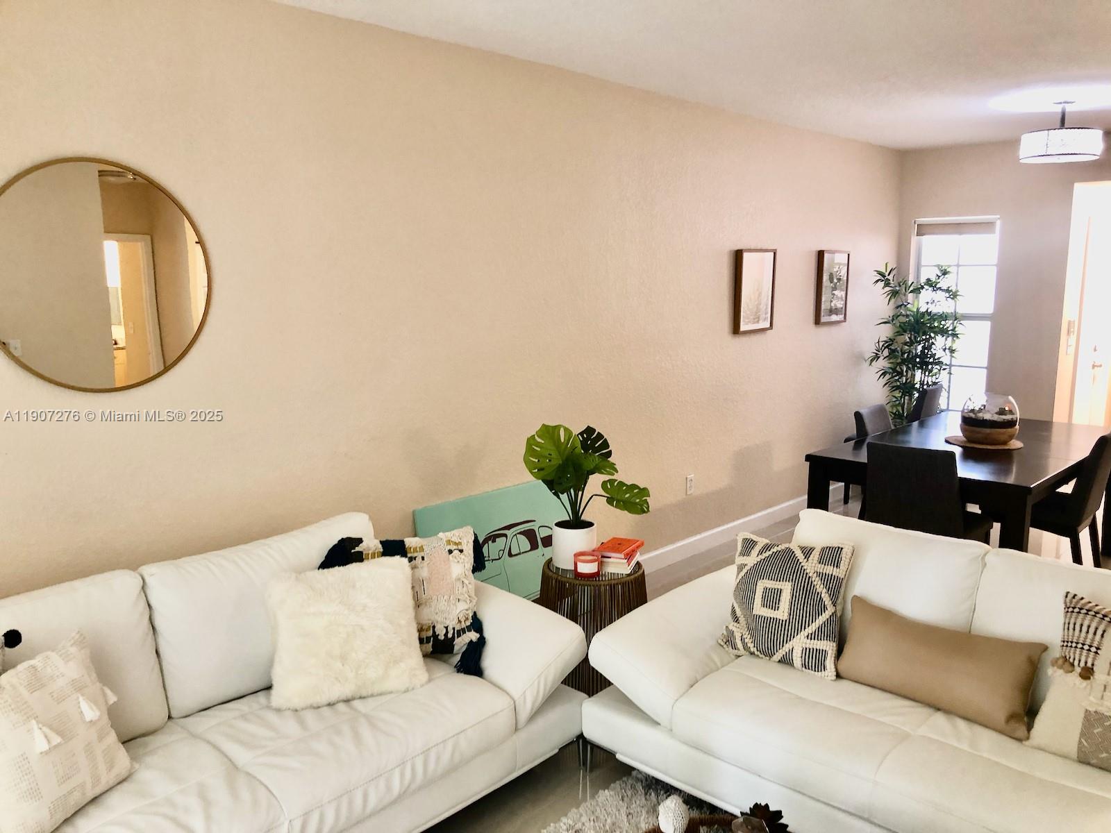 2532 Centergate Drive, Unit 102 Miramar, FL 33025 - Photo 19 of 58 a living room with furniture and a mirror
