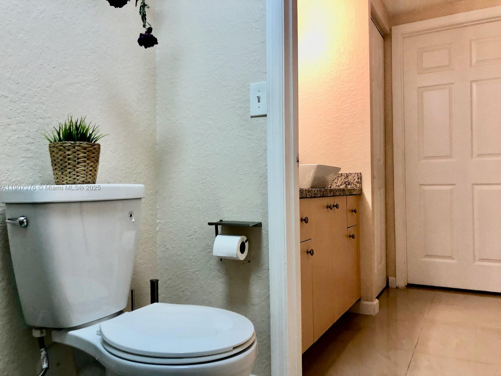 2532 Centergate Drive, Unit 102 Miramar, FL 33025 - Photo 22 of 58 a white toilet sitting next to a bathroom sink
