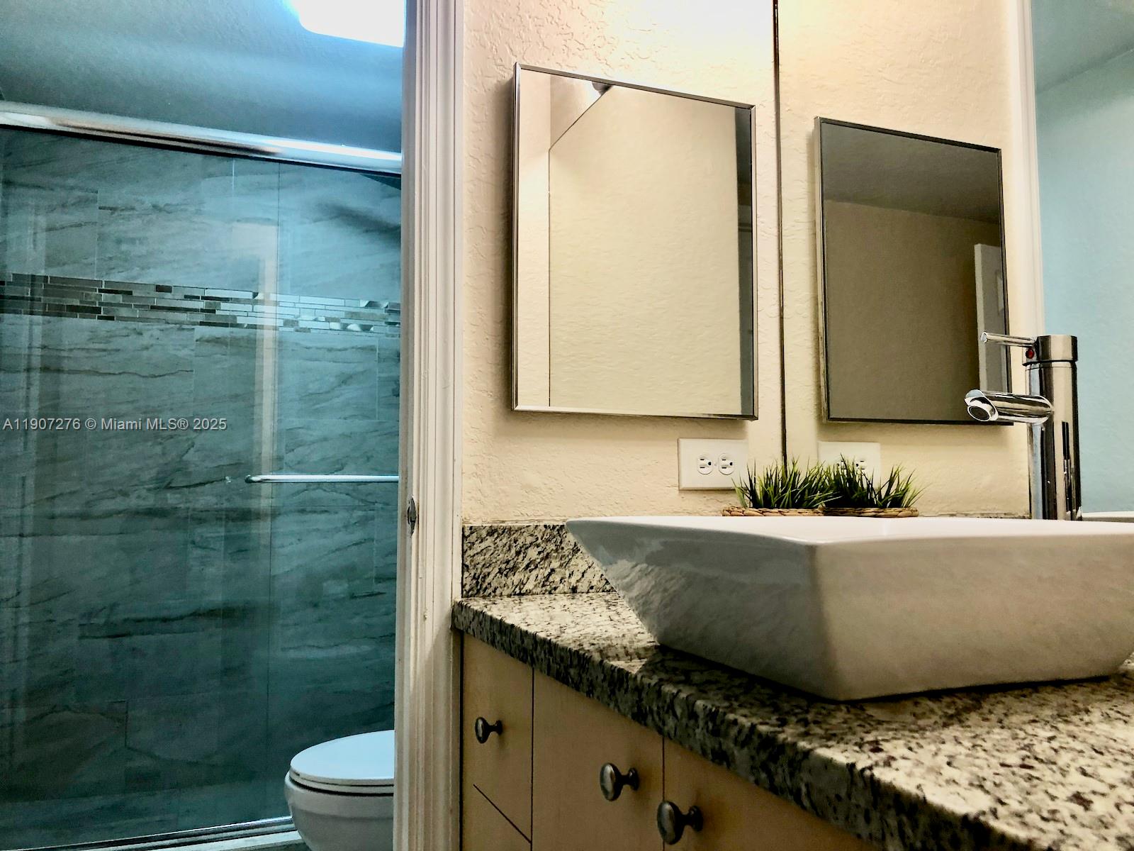 2532 Centergate Drive, Unit 102 Miramar, FL 33025 - Photo 23 of 58 a bathroom with a granite countertop bathtub shower sink vanity and toilet