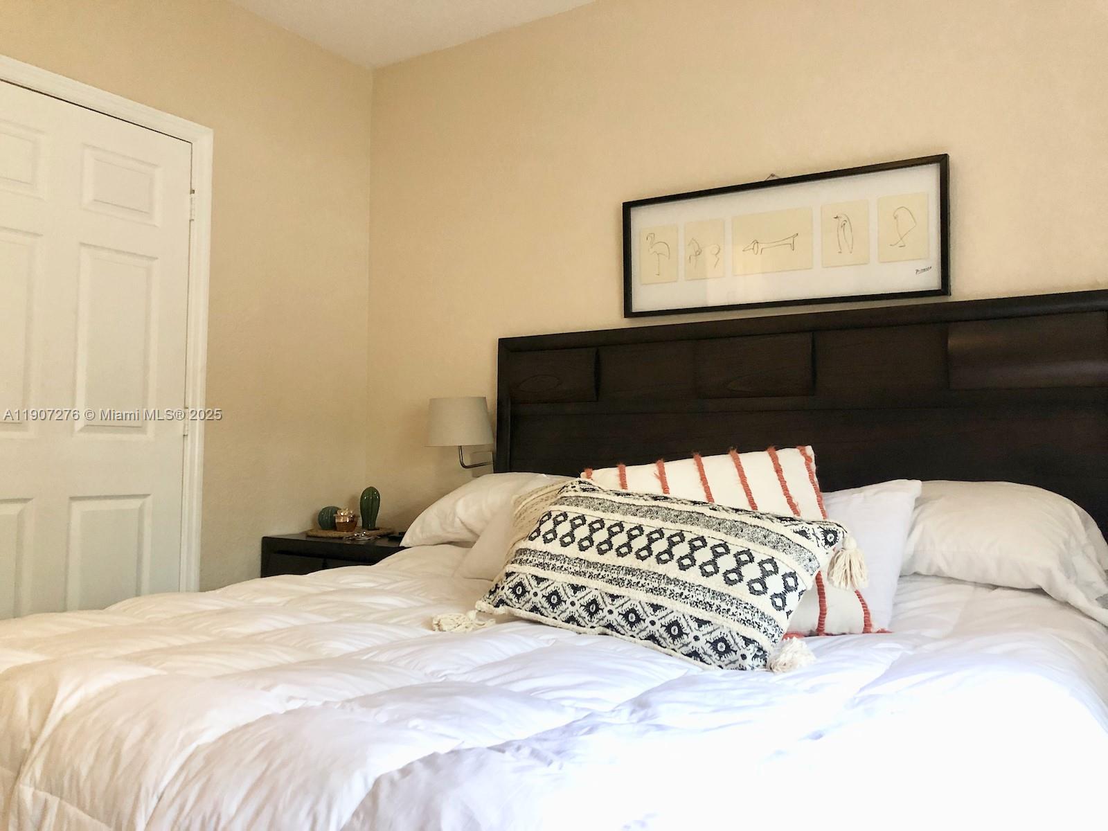 2532 Centergate Drive, Unit 102 Miramar, FL 33025 - Photo 29 of 58 a bedroom with a bed and a night stand