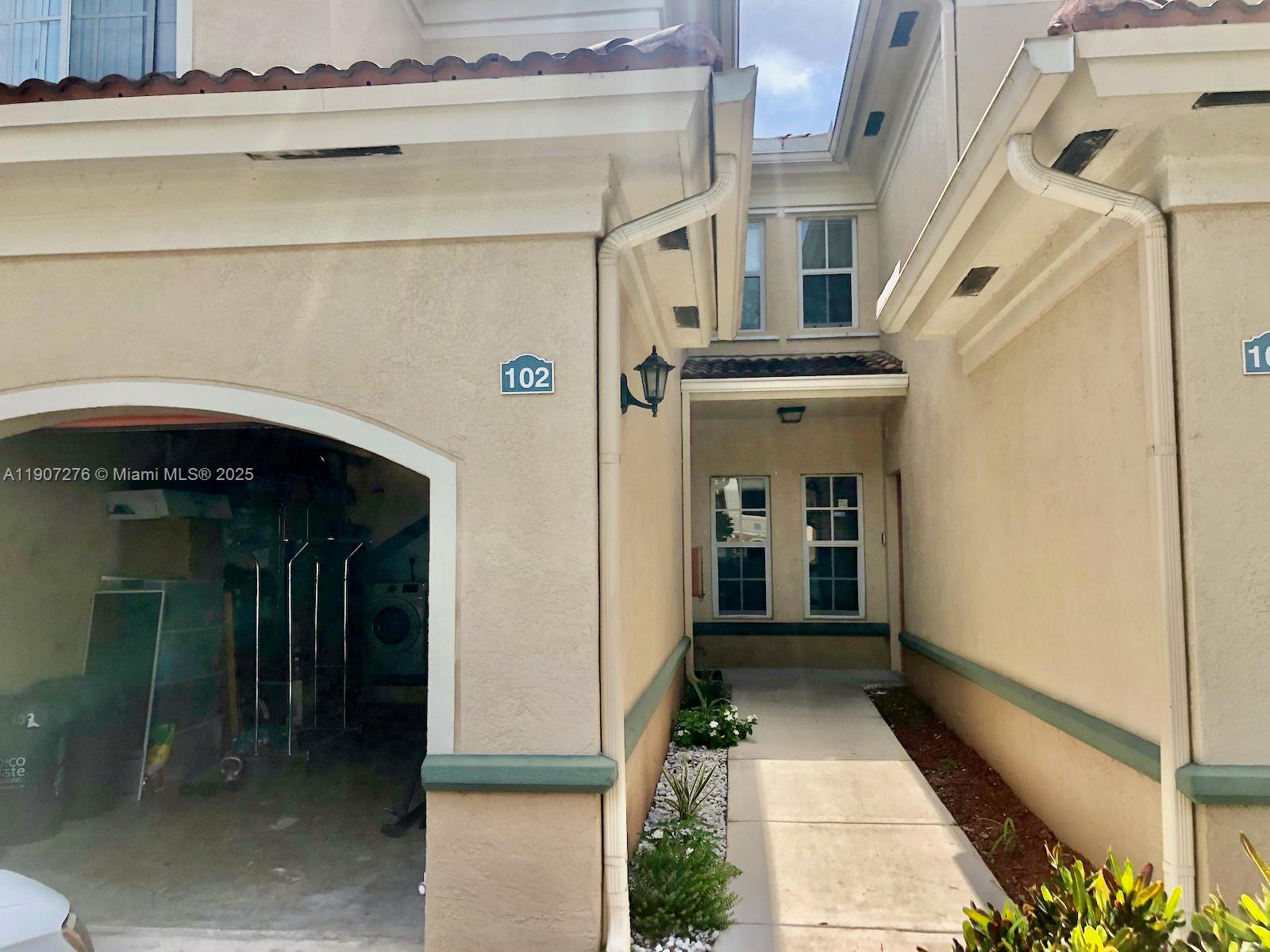 2532 Centergate Drive, Unit 102 Miramar, FL 33025 - Photo 33 of 58 a front view of a house with a lots of windows and plants