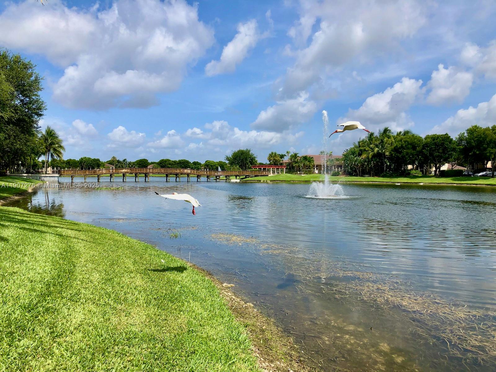 2532 Centergate Drive, Unit 102 Miramar, FL 33025 - Photo 40 of 58 a view of a lake with houses in the back