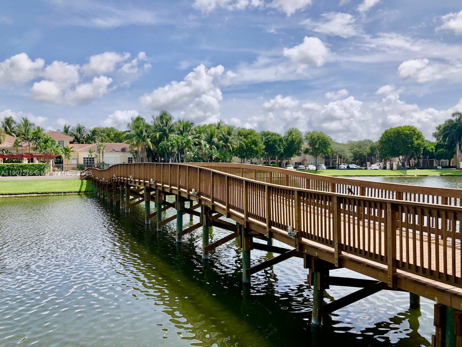 2532 Centergate Drive, Unit 102 Miramar, FL 33025 - Photo 41 of 58 a balcony with wooden floor and lake view