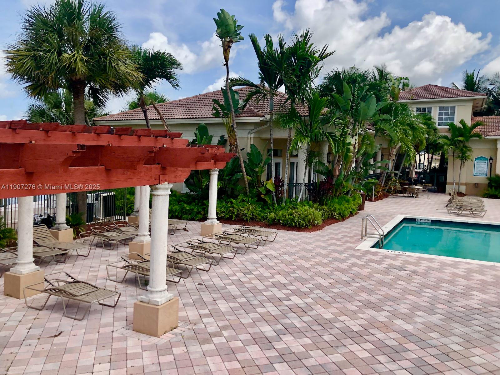 2532 Centergate Drive, Unit 102 Miramar, FL 33025 - Photo 44 of 58 a front view of multi story residential apartment building with yard and sign board