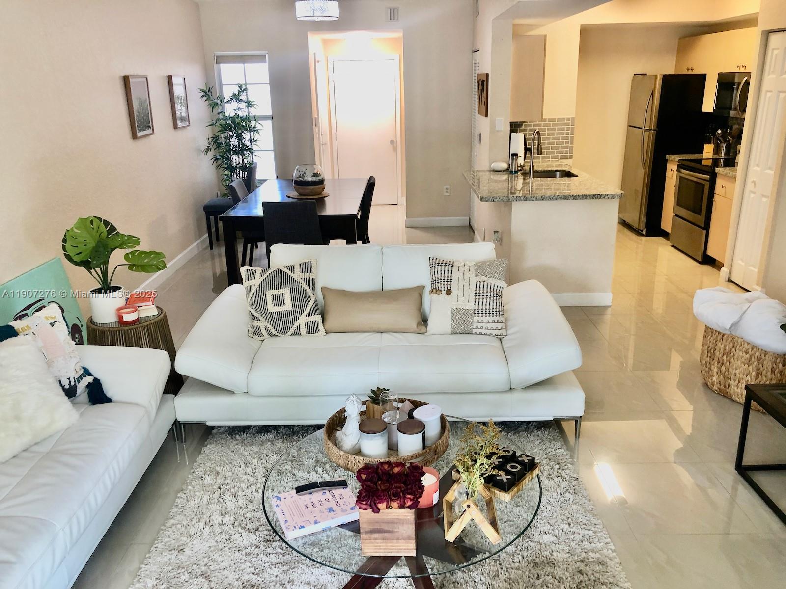 2532 Centergate Drive, Unit 102 Miramar, FL 33025 - Photo 5 of 58 a living room with furniture and a flat screen tv