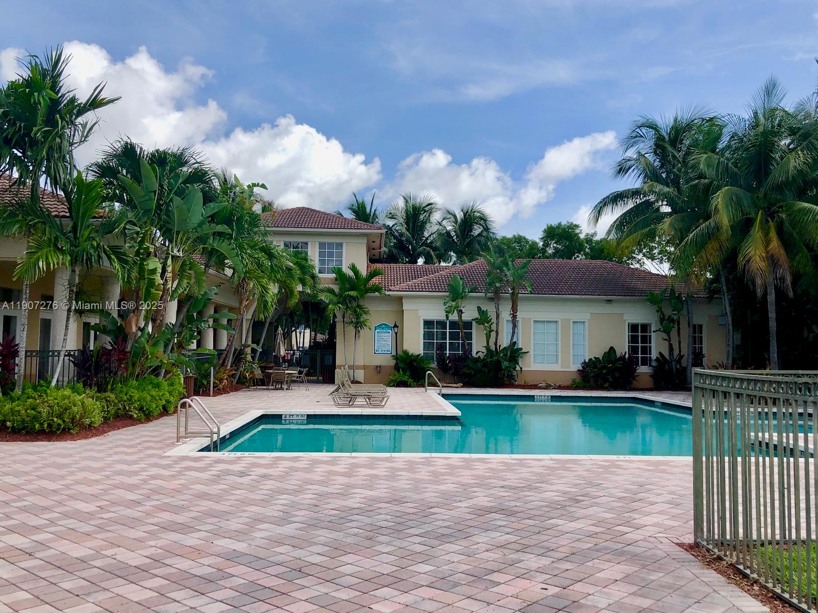 2532 Centergate Drive, Unit 102 Miramar, FL 33025 - Photo 51 of 58 a view of a white house with a yard and potted plants