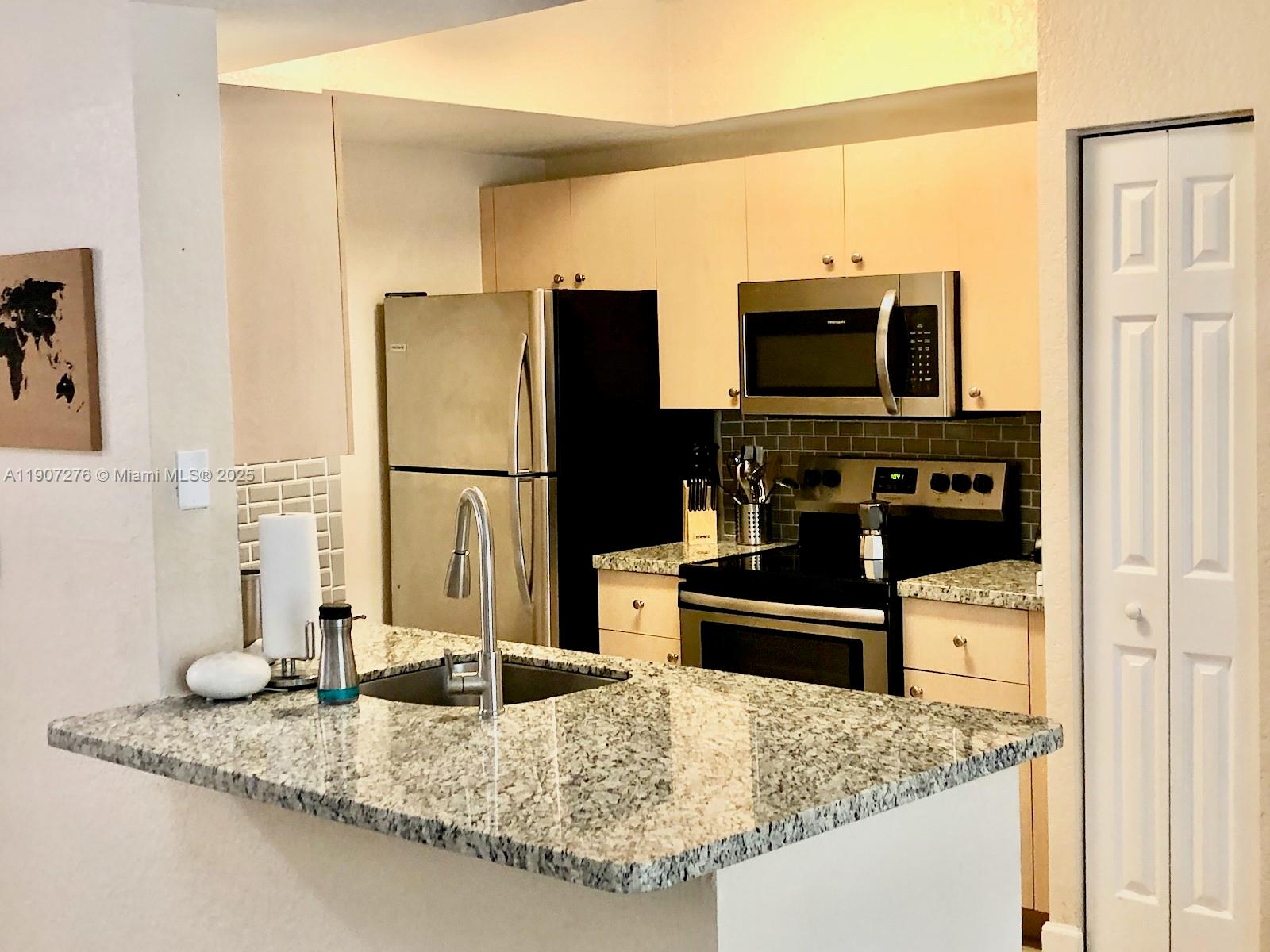 2532 Centergate Drive, Unit 102 Miramar, FL 33025 - Photo 8 of 58 a kitchen with stainless steel appliances granite countertop a refrigerator and a sink