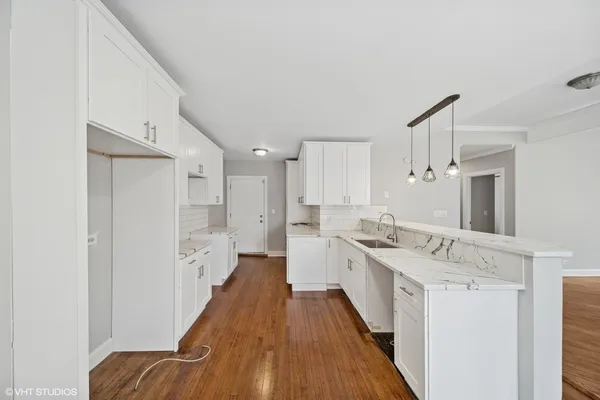 a view of a kitchen with a sink and wooden floor