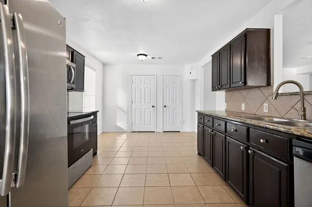 a kitchen with granite countertop stainless steel appliances and wooden cabinets