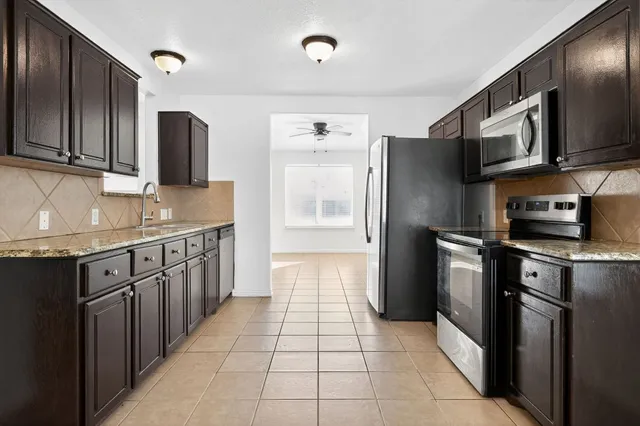 a kitchen with stainless steel appliances granite countertop a refrigerator and a sink