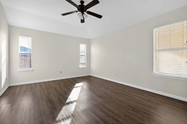 a view of a room with wooden floor and windows