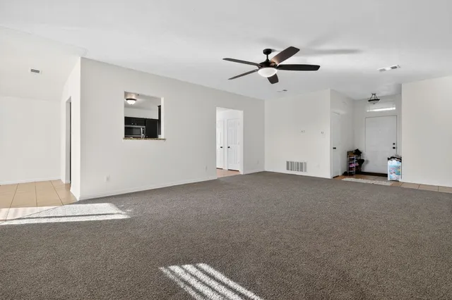 a view of a livingroom with a ceiling fan and window