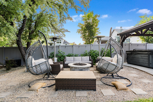 313 Old Maple Road South Weber, UT 84405 - Photo 26 of 35 Landscaped backyard featuring a central fire pit, stone pavers, and a gravel surface