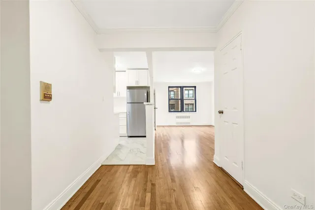 a view of a room with wooden floor and white walls