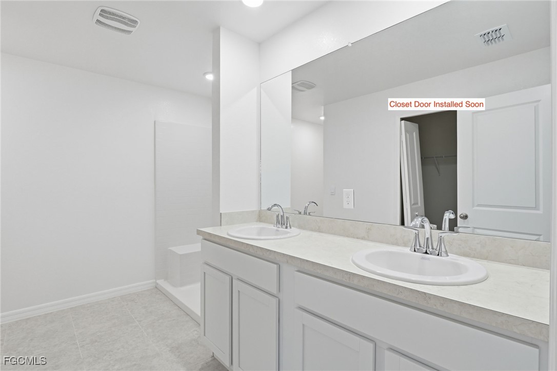 3418 20th Street Southwest Lehigh Acres, FL 33976 - Photo 16 of 34 a bathroom with a sink and a mirror