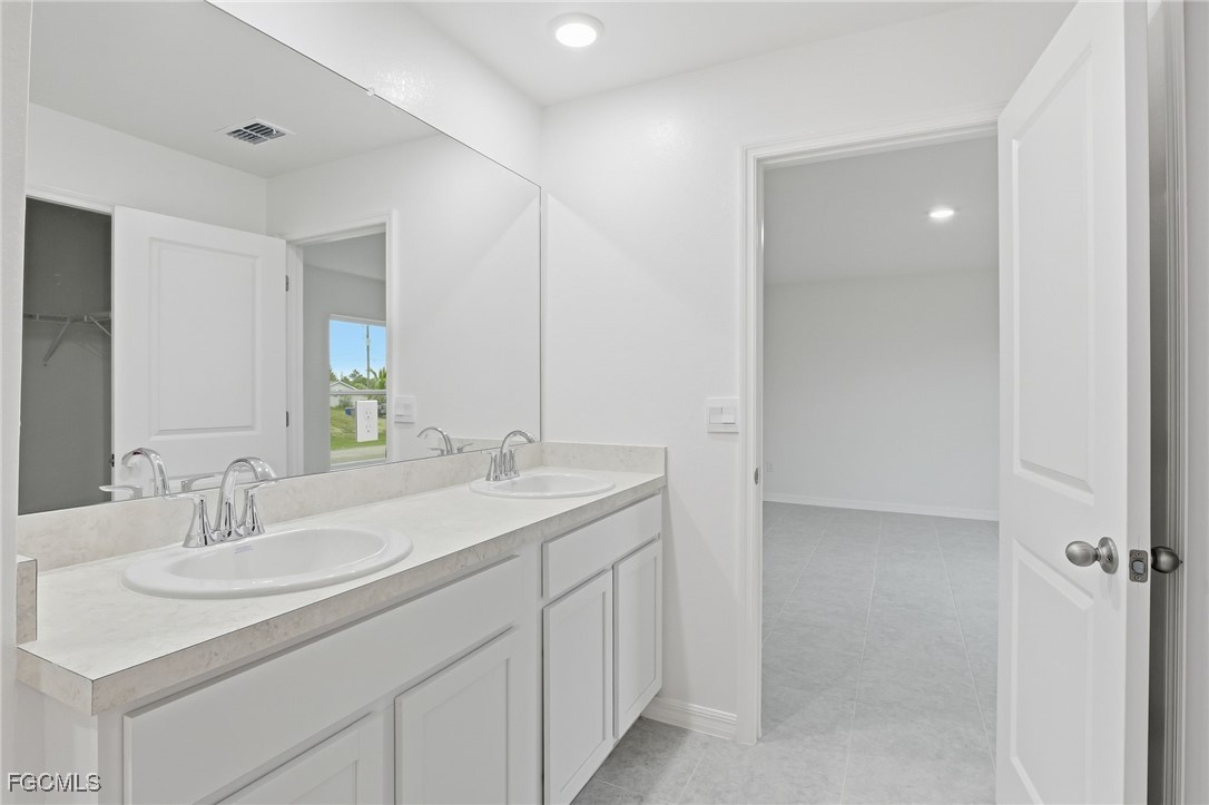 3418 20th Street Southwest Lehigh Acres, FL 33976 - Photo 17 of 34 a bathroom with a sink and a mirror