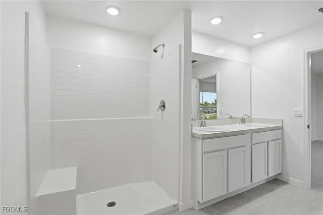 a bathroom with a shower sink vanity and mirror