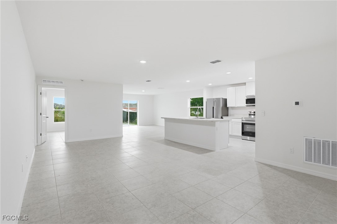 3418 20th Street Southwest Lehigh Acres, FL 33976 - Photo 2 of 34 a view of a kitchen with furniture and wooden floor