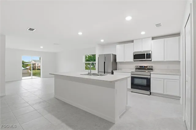 a kitchen with granite countertop a stove top oven and cabinets