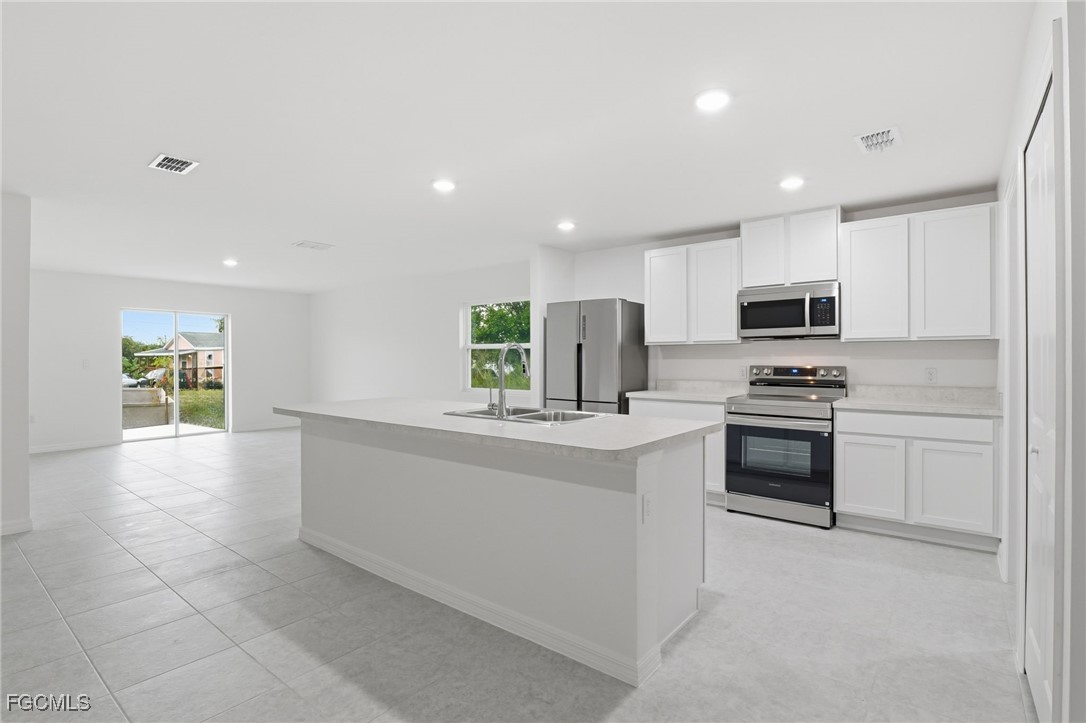 3418 20th Street Southwest Lehigh Acres, FL 33976 - Photo 5 of 34 a kitchen with granite countertop a stove top oven and cabinets