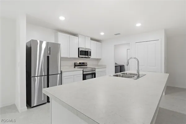 a kitchen with stainless steel appliances a refrigerator stove microwave and sink